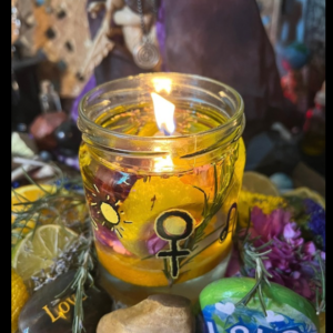 a glass jar with yellow liquid and a flame in the middle. the jar has a venus symbol and various rocks surrounding it